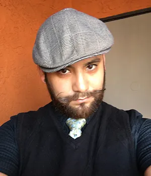 A man with a beard and hat is taking a selfie.
